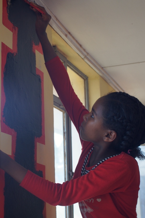 One of the students helping to paint the library, Wollaita style.
